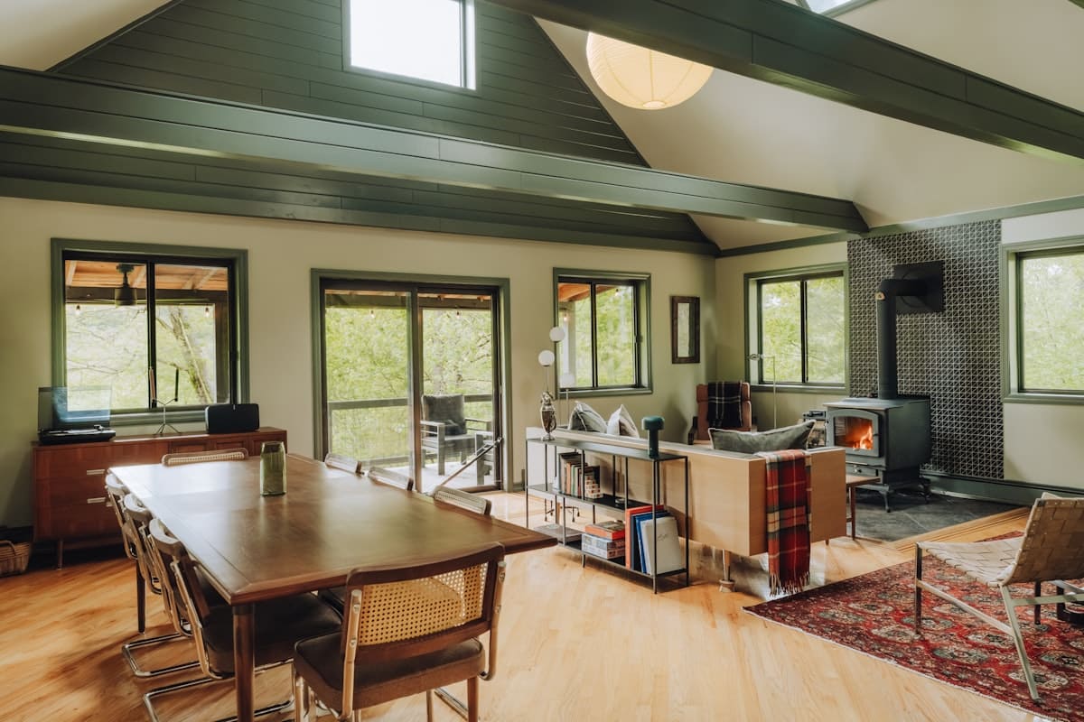 Suncadia mountain home interior great room with vaulted ceiling, wood stove and forest views