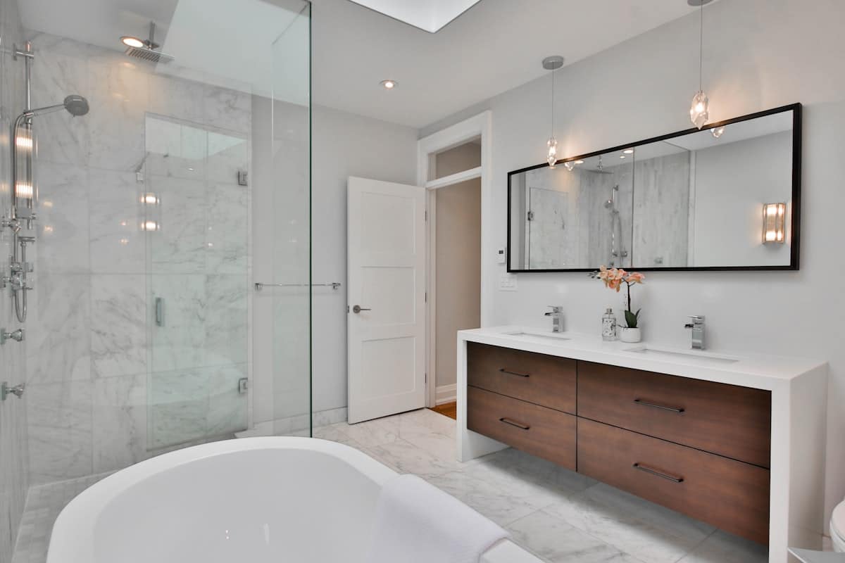 Remodeled Yakima WA bathroom with walnut double vanity, glass walk-in shower and soaking tub